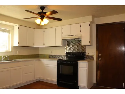 a kitchen with a sink dishwasher and white cabinets