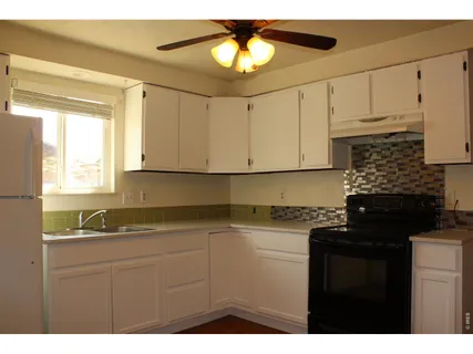 a kitchen with a sink dishwasher and white cabinets