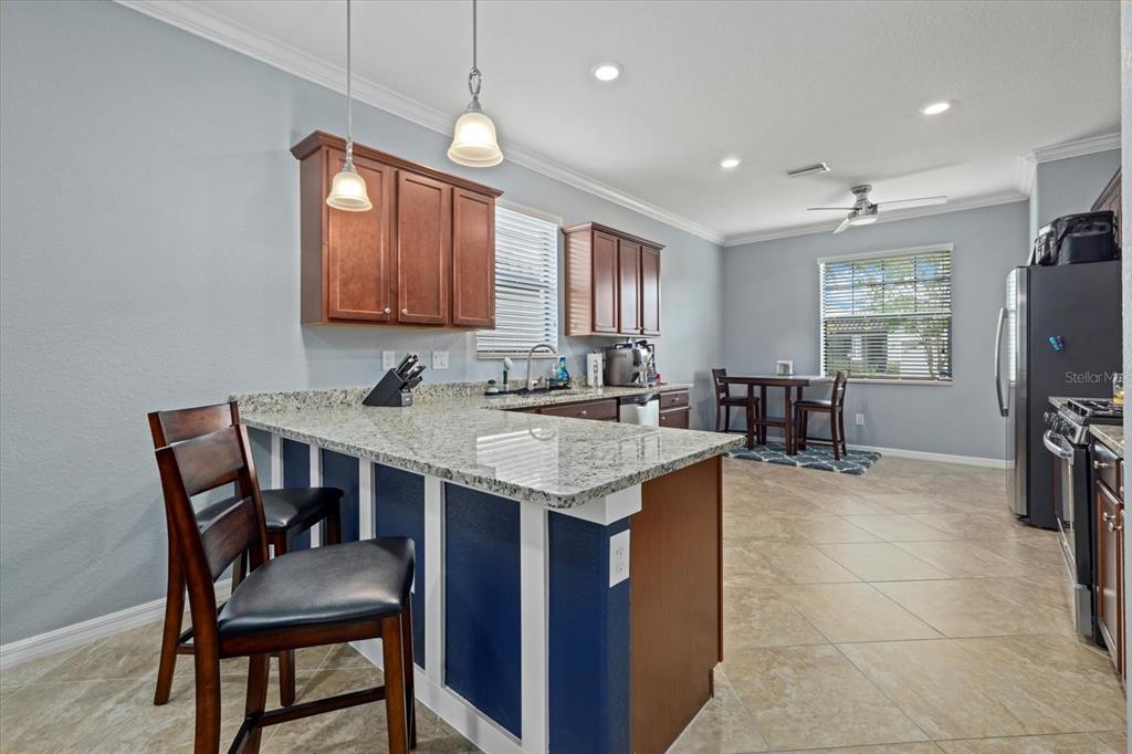 17018 Blue Rdg Place Bradenton, FL 34211 - Photo 11 of 34 a kitchen with a stove a sink a dining table and chairs