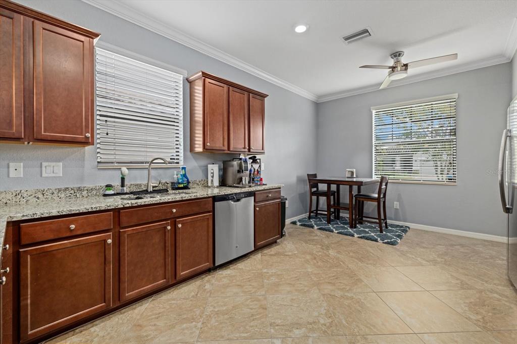 17018 Blue Rdg Place Bradenton, FL 34211 - Photo 12 of 34 a kitchen with stainless steel appliances granite countertop sink a window and white cabinets