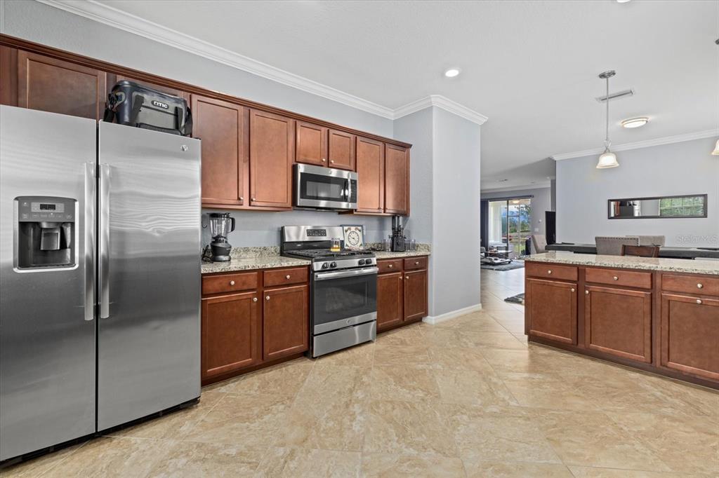 17018 Blue Rdg Place Bradenton, FL 34211 - Photo 14 of 34 a large kitchen with stainless steel appliances granite countertop a stove a sink dishwasher a refrigerator and a microwave oven