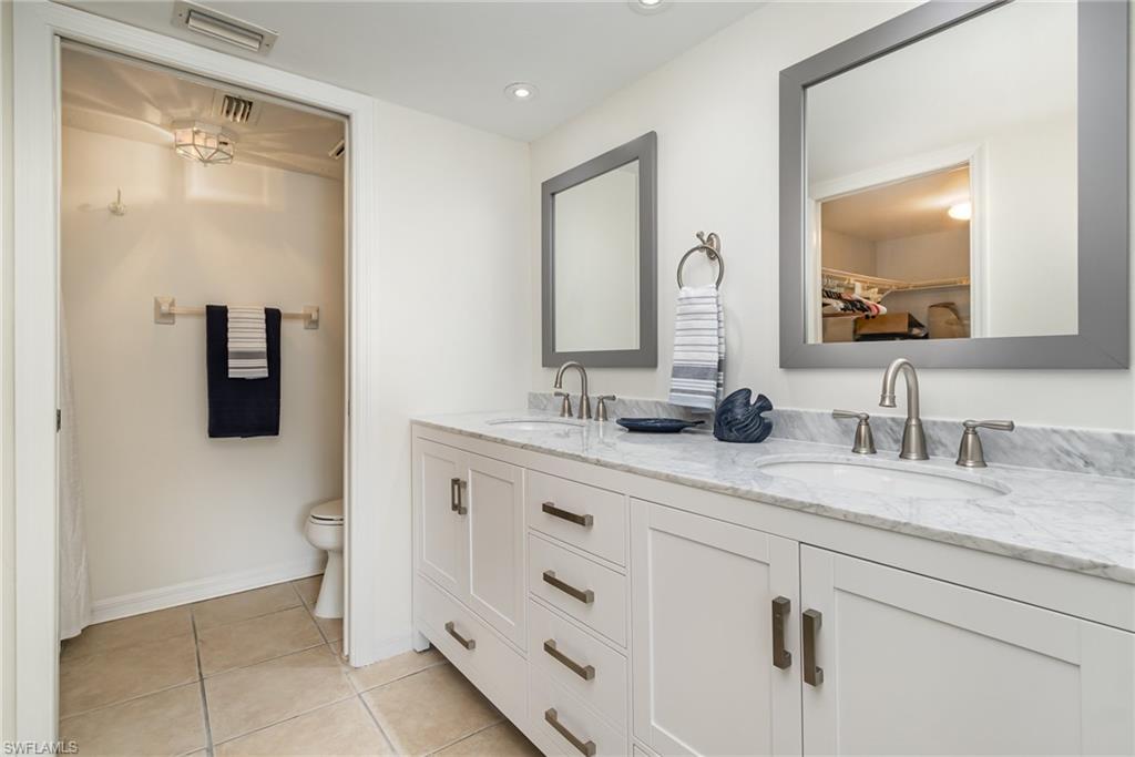 5535 Rattlesnake Hammock Road, Unit 103 Naples, FL 34113 - Photo 11 of 25 Primary Bathroom featuring new, double vanity, new mirrors, updated toilet and shower.