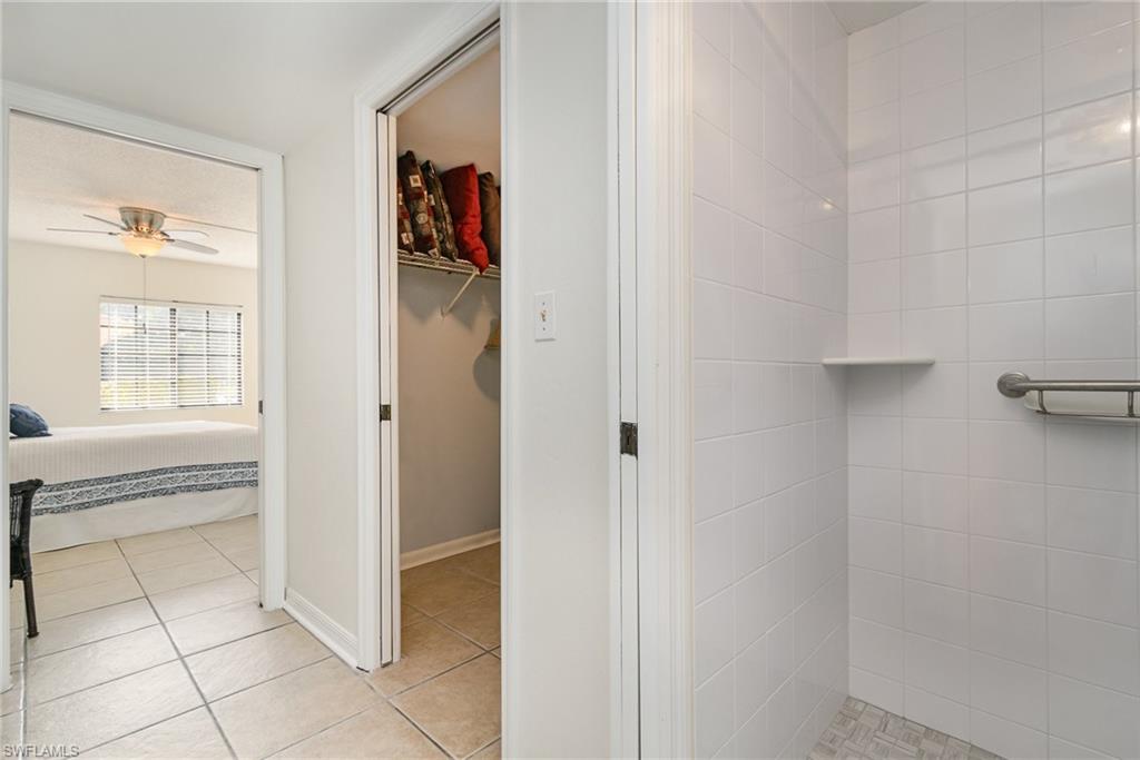 5535 Rattlesnake Hammock Road, Unit 103 Naples, FL 34113 - Photo 12 of 25 Primary Bathroom with updated tiled shower and toilet, separated by pocket door for additional privacy.