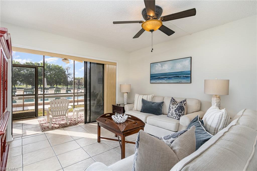 5535 Rattlesnake Hammock Road, Unit 103 Naples, FL 34113 - Photo 2 of 25 Tiled living room featuring ceiling fan and lots of natural light.