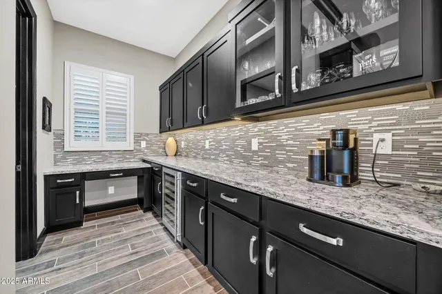 a kitchen with stainless steel appliances granite countertop a sink a stove and a wooden floors