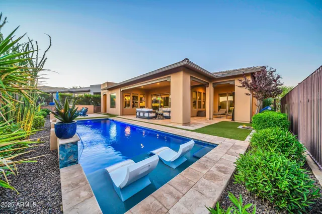 a view of swimming pool with outdoor seating and plants