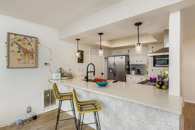 a room with stainless steel appliances kitchen island granite countertop furniture and a refrigerator