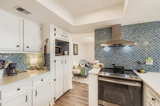 a kitchen with stainless steel appliances a stove microwave and cabinets