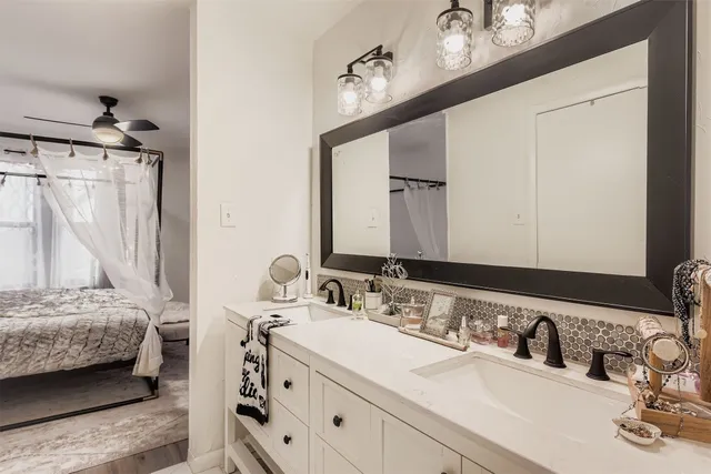 a en suite bathroom with a double vanity sink and a mirror