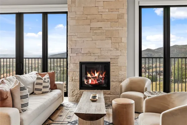 a living room with furniture a fireplace and a large window