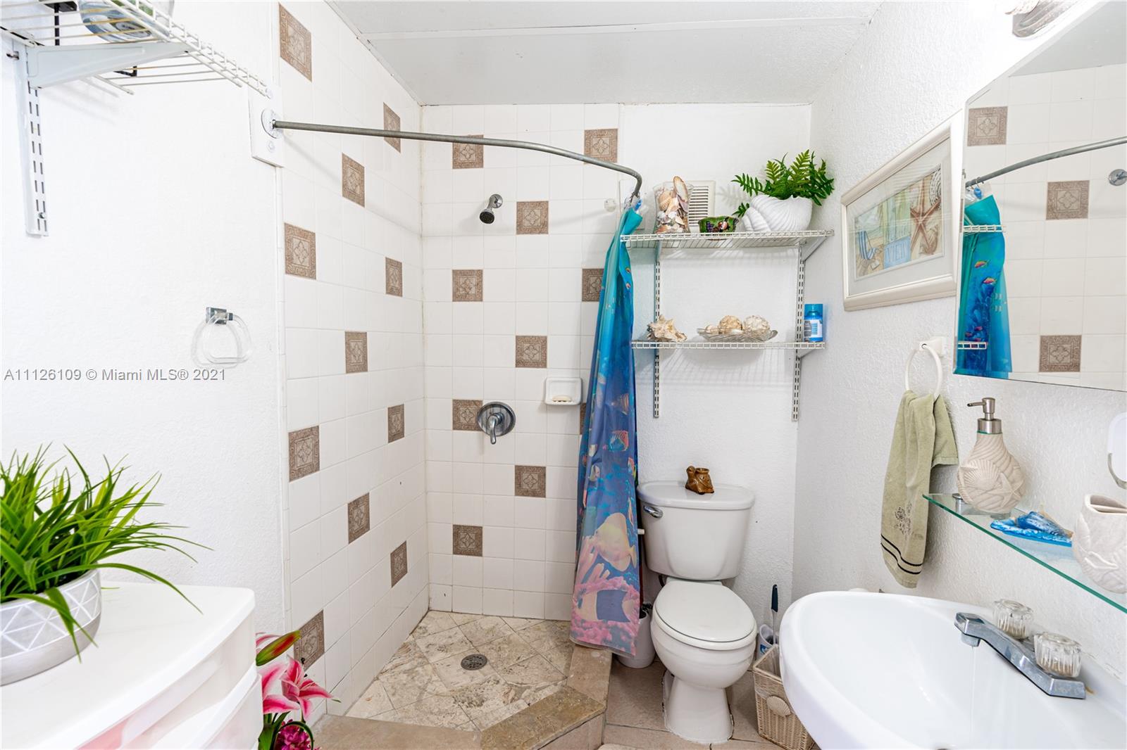6181 Southwest 20th Street West Miami, FL 33155 - Photo 13 of 31 a white toilet sitting next to a bathroom sink and a shower