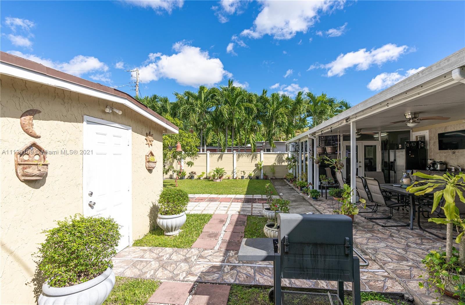 6181 Southwest 20th Street West Miami, FL 33155 - Photo 23 of 31 a view of a patio with table and chairs potted plants and floor to ceiling window