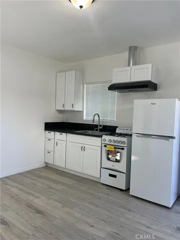 a kitchen with cabinets and wooden floor