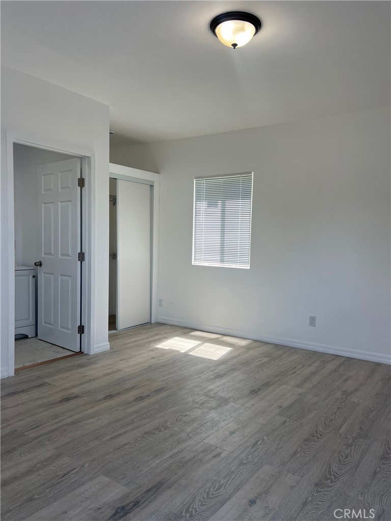 18740 Valerio Street Reseda, CA 91335 - Photo 4 of 5 an empty room with wooden floor and windows