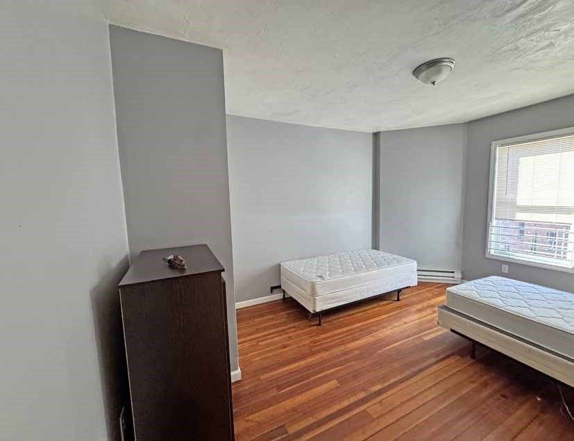 190 Washington Street Lynn, MA 01902 - Photo 15 of 19 a bedroom with a bed and wooden floor