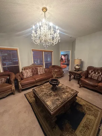 a living room with furniture and a chandelier