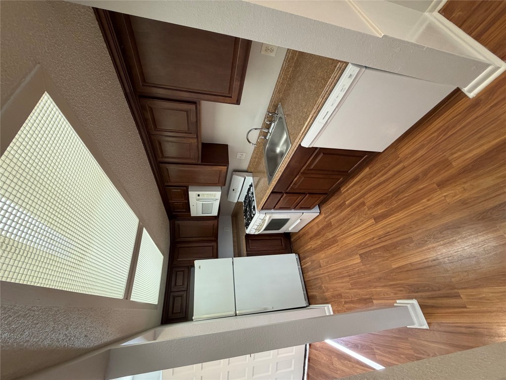1725 Toomey Road, Unit 310 Austin, TX 78704 - Photo 6 of 11 a kitchen with wooden floors and white stainless steel appliances