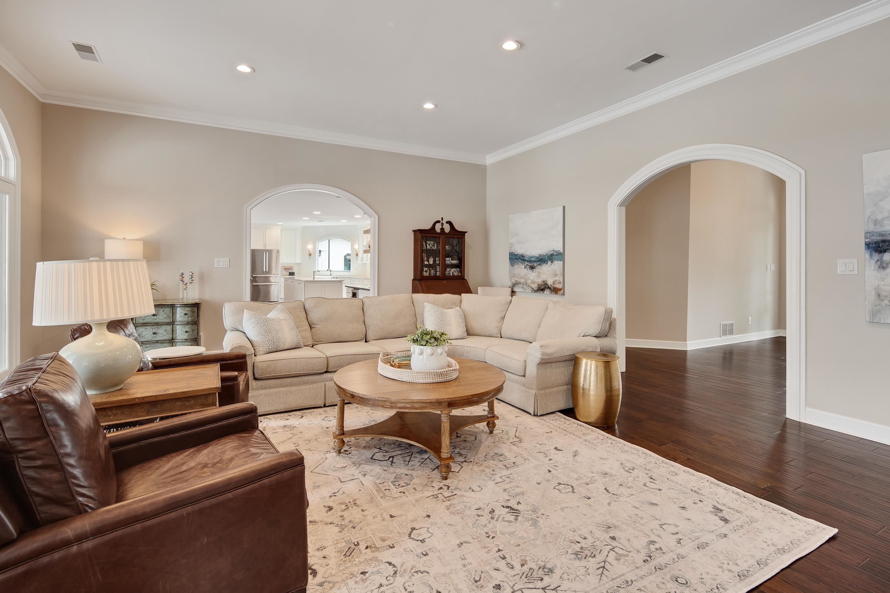 10471 Collierville Road Collierville, TN 38017 - Photo 5 of 40 Living area featuring arched walkways, visible vents, crown molding, and wood finished floors