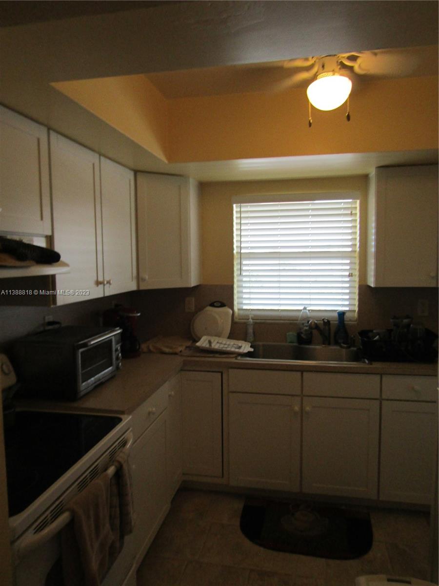 651 Pine Drive, Unit 309 Pompano Beach, FL 33060 - Photo 15 of 38 a kitchen with a sink and cabinets