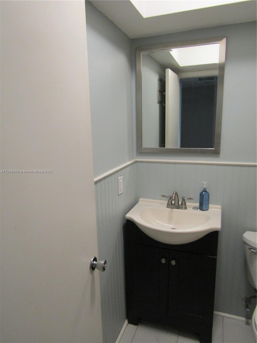 651 Pine Drive, Unit 309 Pompano Beach, FL 33060 - Photo 22 of 38 a bathroom with a sink a mirror and vanity