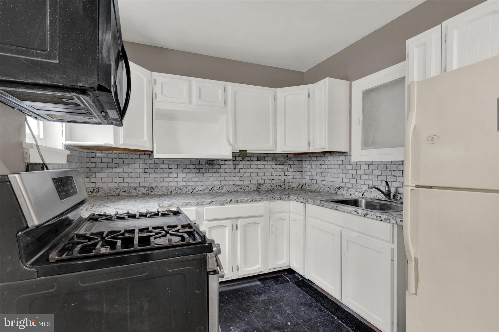 131 Mulberry Street Reading, PA 19601 - Photo 5 of 24 a kitchen with white cabinets and appliances