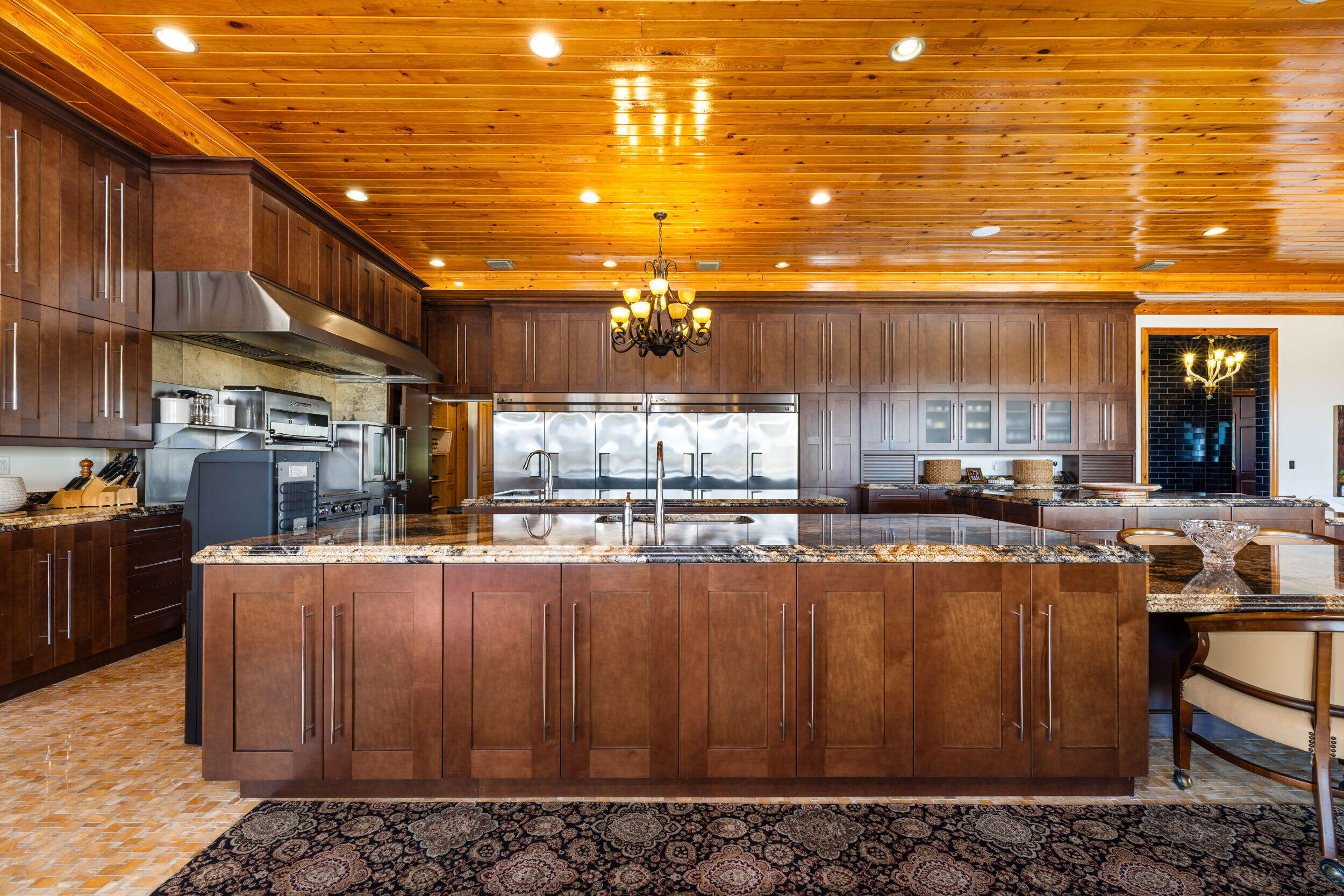 9508 Windy Ridge Road Windermere, FL 34786 - Photo 11 of 49 a kitchen with stainless steel appliances kitchen island granite countertop a table chairs in it and wooden floors