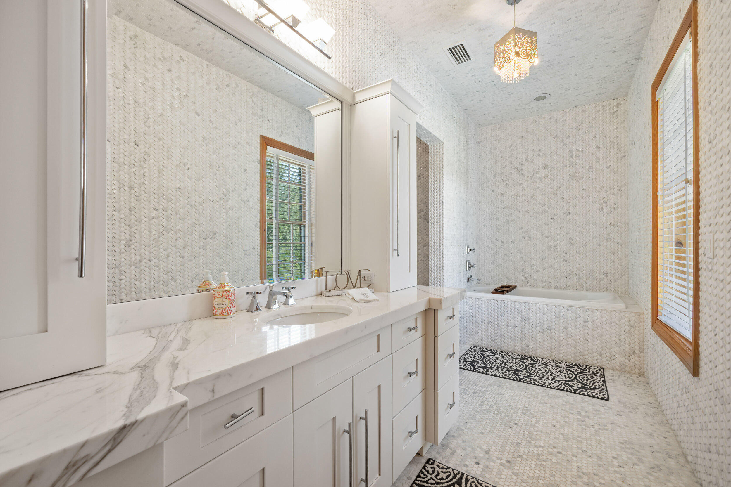 9508 Windy Ridge Road Windermere, FL 34786 - Photo 24 of 49 a bathroom with a tub a sink and a large mirror