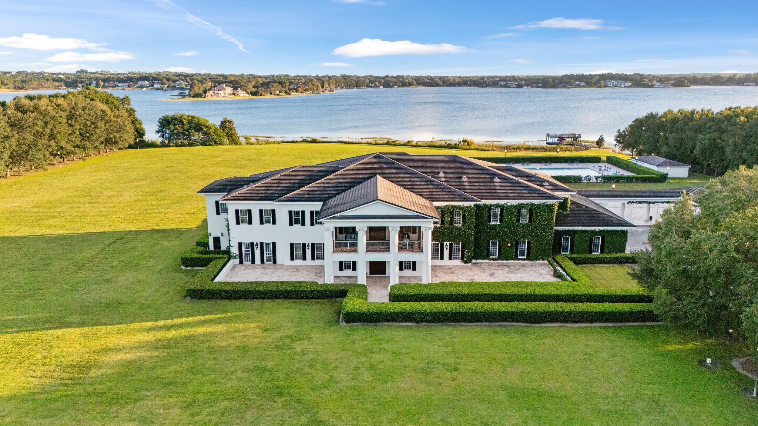 9508 Windy Ridge Road Windermere, FL 34786 - Photo 3 of 49 a front view of a house with a garden and lake view