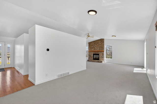 380 Luzern Road Midway, UT 84049 - Photo 19 of 74 Spacious living area featuring a stone fireplace, light-toned carpeting, and white walls