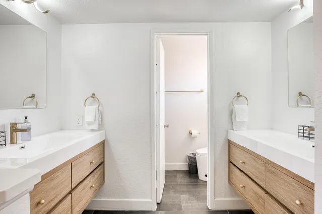 a bathroom with a sink a toilet and a large mirror