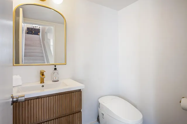 a bathroom with a toilet sink and mirror