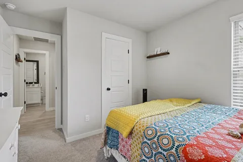 a bedroom with a bed and a painting on the wall