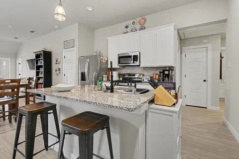 a kitchen with stainless steel appliances granite countertop a stove a sink and a refrigerator
