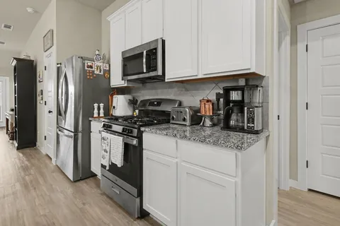 a kitchen with stainless steel appliances granite countertop a refrigerator stove and microwave