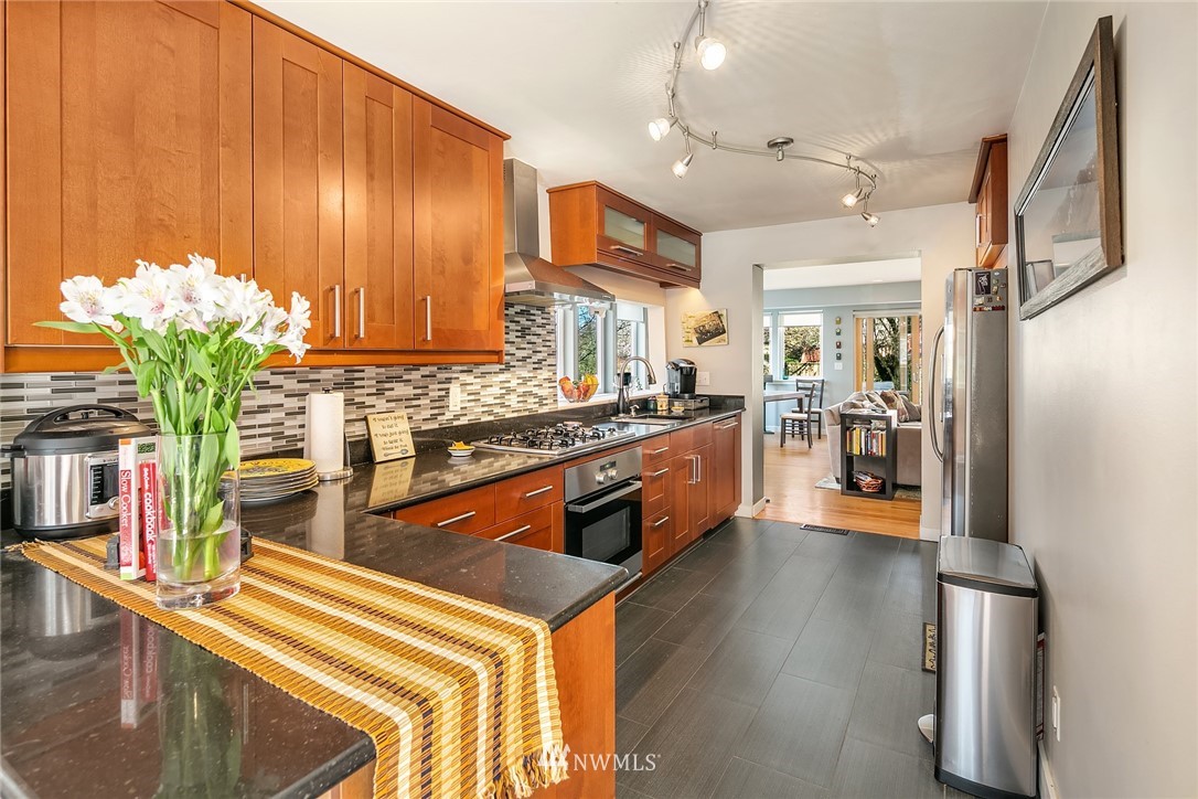 342 Northwest 48th Street Seattle, WA 98107 - Photo 7 of 20 a kitchen with stainless steel appliances granite countertop a refrigerator a stove and a wooden floors