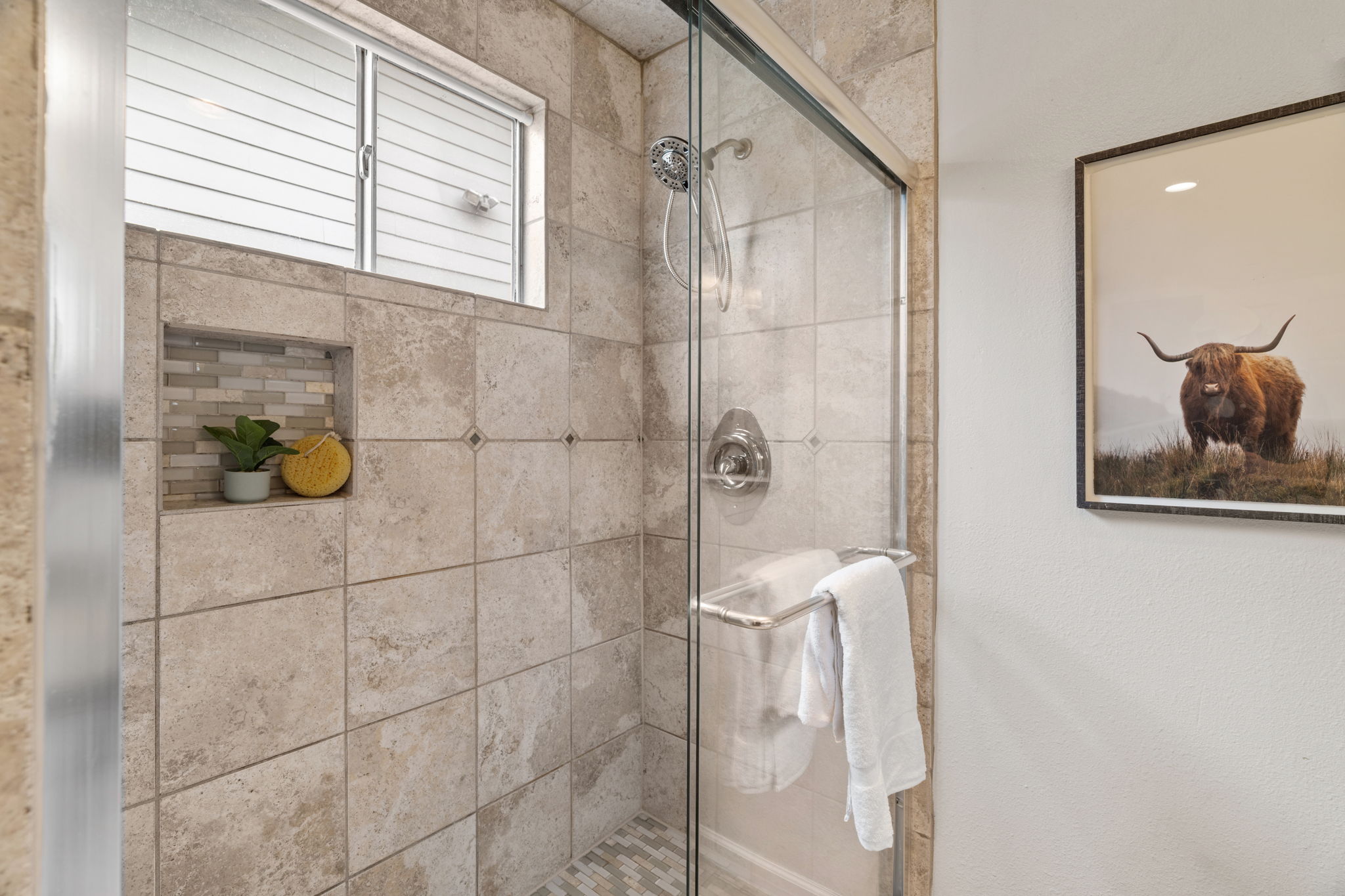 2604 Cockburn Drive Austin, TX 78745 - Photo 22 of 34 A beautifully tiled walk in shower adds a spa inspired touch to the primary bathroom.