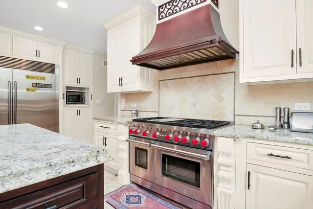 a kitchen with granite countertop a sink stove and cabinets