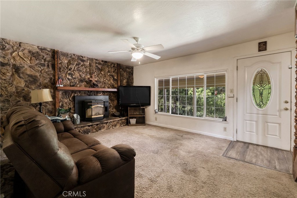 5048 Big Bend Road Oroville, CA 95965 - Photo 14 of 75 a living room with furniture a fireplace a flat screen tv and a large window