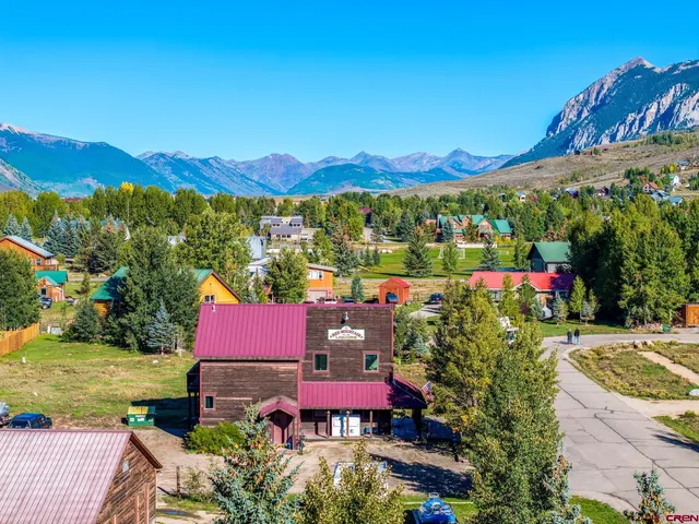 a aerial view of a house with a yard and lake view