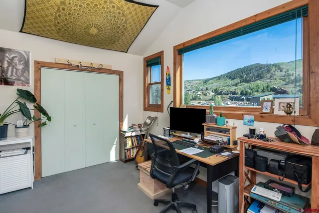 a view of a workspace with furniture and a window
