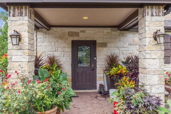 a front view of a house with a lot of flowers