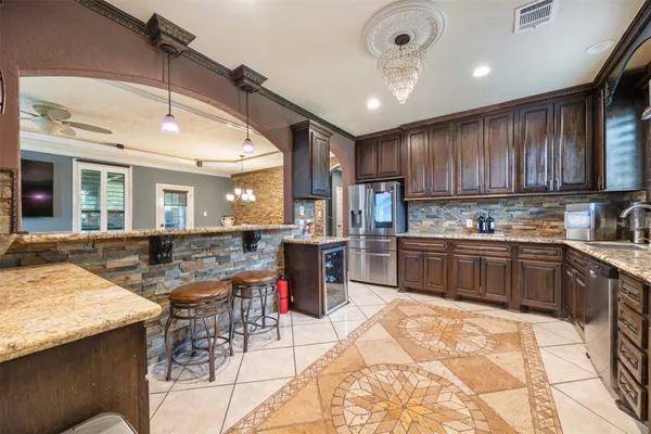 a kitchen with stainless steel appliances kitchen island granite countertop a sink and cabinets