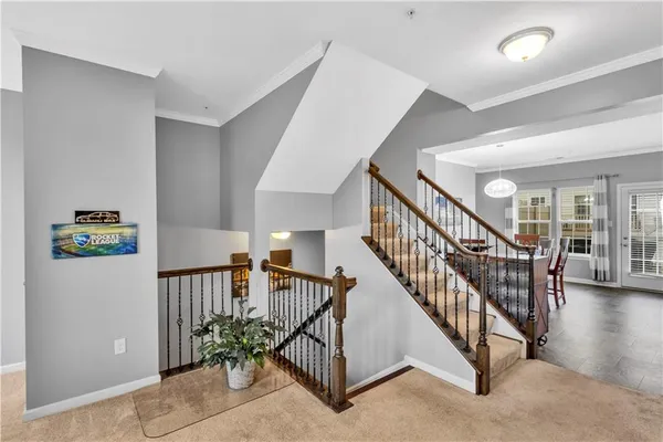 a view of staircase with lots of frames and white walls