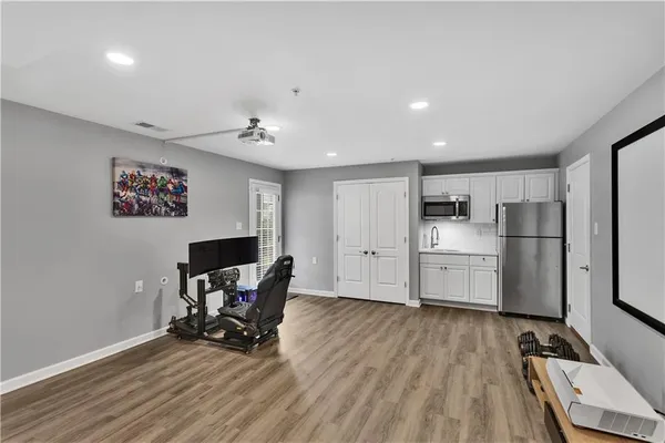 a view of a kitchen with refrigerator and wooden floor