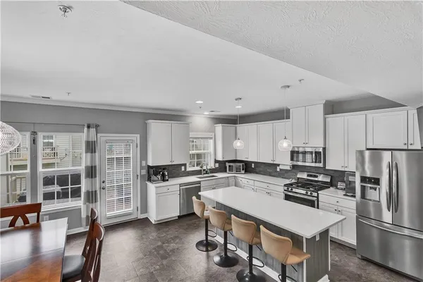 a kitchen with white cabinets and stainless steel appliances