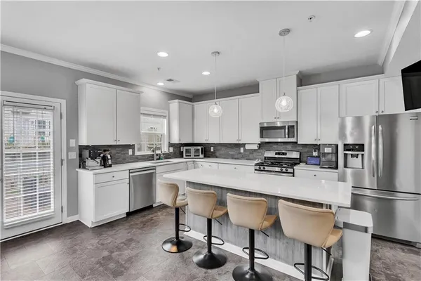 a kitchen with a refrigerator a stove a sink cabinets and a dining table