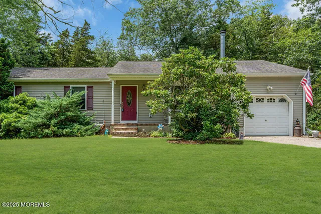 a front view of a house with a yard and trees