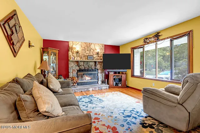 a living room with furniture a fireplace and floor to ceiling windows