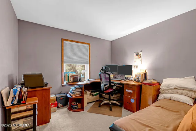 a view of a workspace with furniture and a window