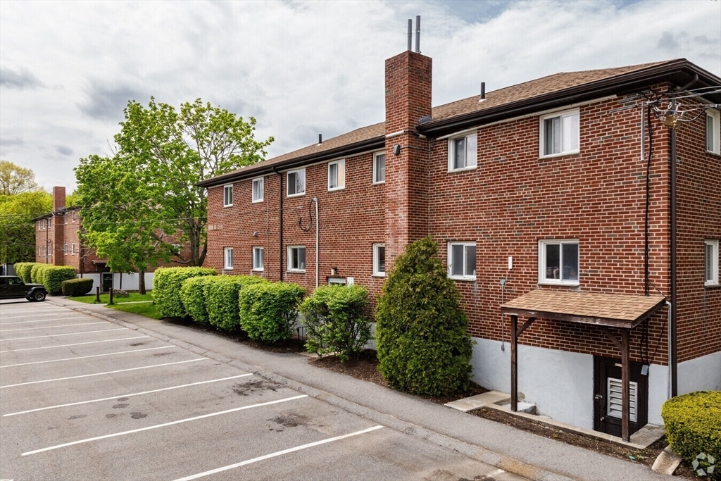 42 Bryon Road, Unit 6 Boston, MA 02467 - Photo 12 of 16 a front view of a house with a yard and plants